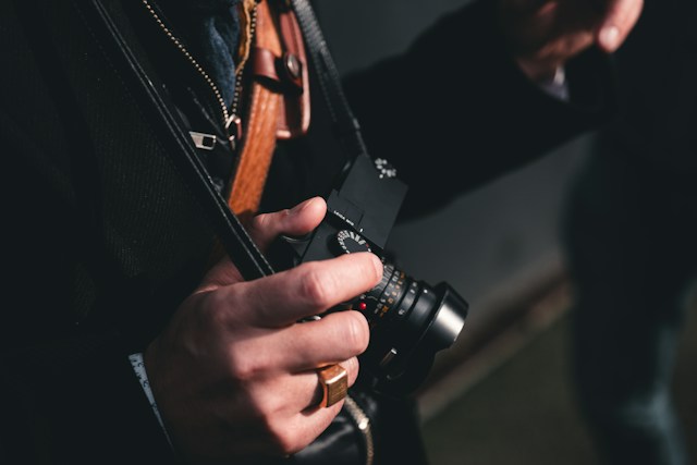 main d'une personne tenant un appareil photo Leica